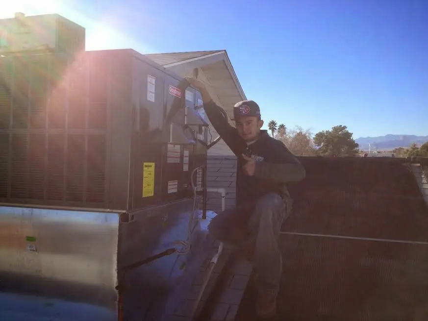 HVAC technician performing Heat Pump Repair on a rooftop unit in Burtonsville